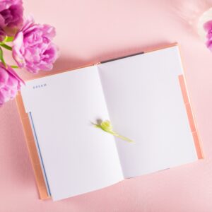 Open Notebook for writing Dreams and Ideas with flowers nearby
